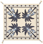 The Ikat Amazónico Napkins by Johanna Ortiz feature a cream background, blue and navy palm tree motifs, a decorative border, and tassels—perfect for adding tropical chic elegance to your table setting.