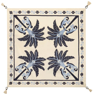 The Ikat Amazónico Napkins by Johanna Ortiz feature a cream background, blue and navy palm tree motifs, a decorative border, and tassels—perfect for adding tropical chic elegance to your table setting.