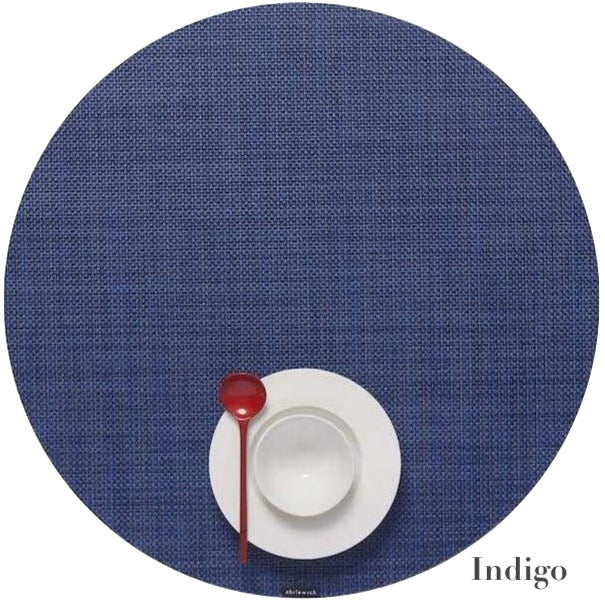 A red spoon, white saucer, and empty cup are arranged on a Chilewich round placemat from the Round Placemat Collection, crafted with phthalate-free Terrastrand yarns.