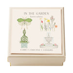 Karen Adams’ “In the Garden Gift Enclosures” features a cream-colored box with hand-glittered illustrations of a moth, flowers, topiary, and fountain. Includes 8 enclosure cards and 8 envelopes.