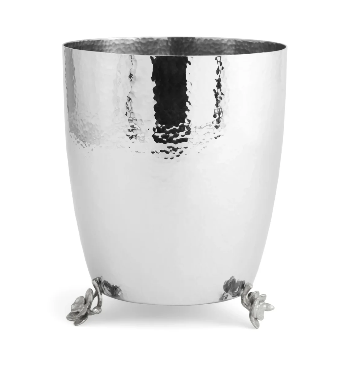 The Michael Aram White Orchid Bath Collection features a hammered metal ice bucket with a reflective surface and three sculpted leaf-shaped feet at the base, which pairs beautifully with orchid-inspired bathroom accessories like the luxury soap dispenser for an elegant and cohesive look.