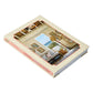 A hardcover book titled “Island Hopping” by Common Ground rests on a flat surface, featuring an interior design photograph on its cover that captures the essence of island living and the breezy elegance of Amanda Lindroth interiors.
