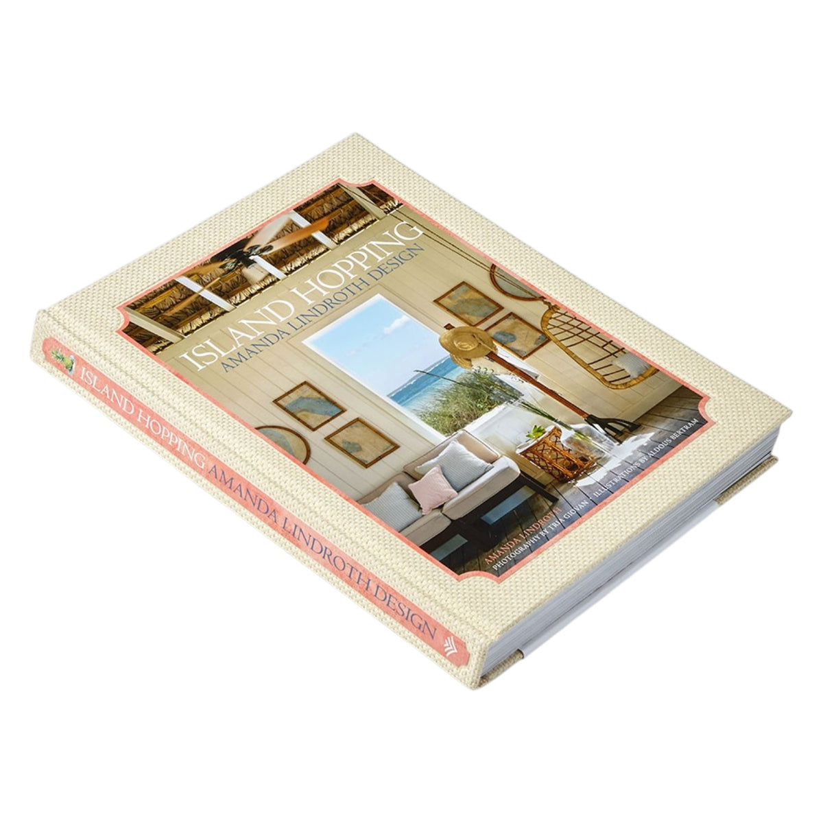 A hardcover book titled “Island Hopping” by Common Ground rests on a flat surface, featuring an interior design photograph on its cover that captures the essence of island living and the breezy elegance of Amanda Lindroth interiors.