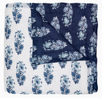 The Kanak Indigo Bedding Collection by John Robshaw features a hand-quilted cotton quilt with indigo and white leaf block print on one side and dark blue with lighter blue leaves on the reverse.