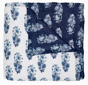 The Kanak Indigo Bedding Collection by John Robshaw features a hand-quilted cotton quilt with indigo and white leaf block print on one side and dark blue with lighter blue leaves on the reverse.