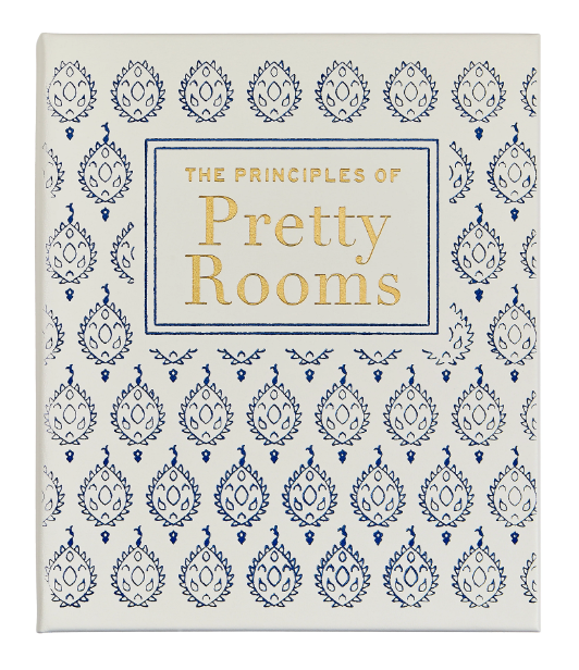 A white book cover titled "The Principles of Pretty Rooms" by Graphic Image features a blue and gold patterned design—an inspiring guide for fans of beautiful, timeless interiors.