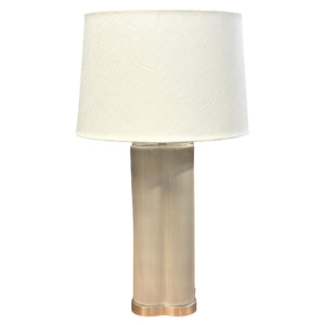 The Stratus Classic Table Lamp by Hwang Bishop features a cylindrical brushed metal base and a plain white fabric shade, offering elegant lighting for any room. Shown here against a white background.