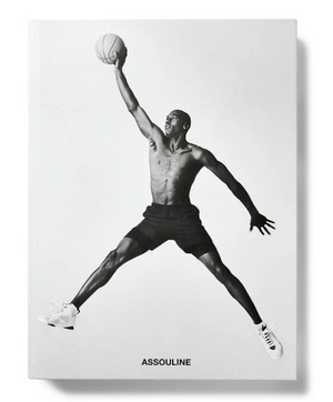 Black and white image of a shirtless basketball player, Air Jordan style, leaping with one arm outstretched holding a basketball; "Assouline" appears at the bottom.