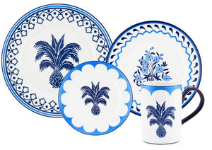 A set of blue and white porcelain dishes and a mug from the Aquazzura Casa Jaipur Blue Dinnerware Collection, featuring handcrafted palm tree and floral designs.