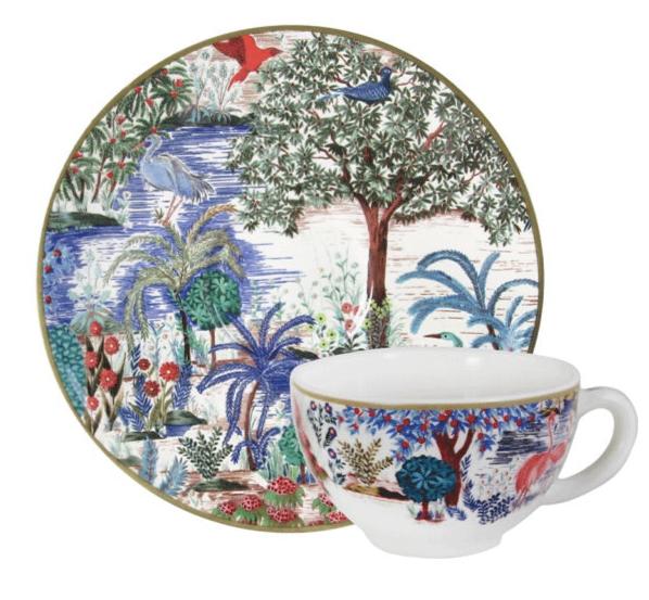 The Gien France Gien x Pierre Jardins Du Palais Tea Cup and Saucer set, featuring detailed, colorful nature scenes with trees, birds, and foliage, reflects the artistry of Pierre Frey's Le Jardin du Palais collection.