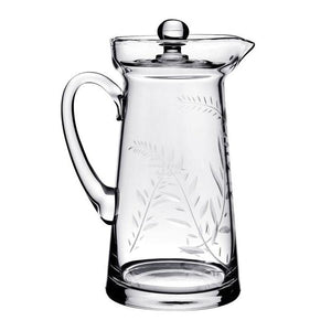 The Jasmine Pitcher Collection by William Yeoward Crystal features a clear glass pitcher with handle and lid, adorned with an elegant leaf and branch etching reminiscent of a cherished wedding gift or jasmine’s delicate beauty.
