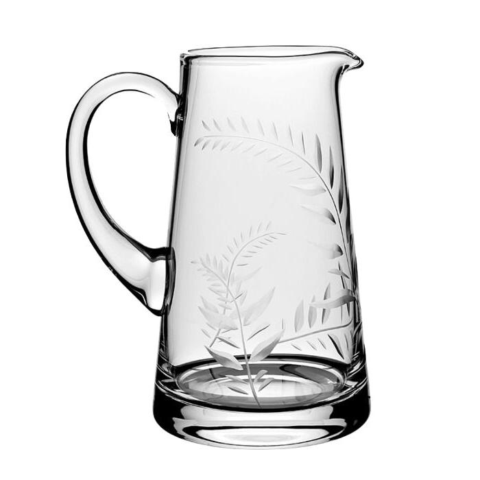 The Jasmine Pitcher Collection by William Yeoward Crystal features a clear glass pitcher with handle, spout, and etched fern leaf design—ideal as a cherished wedding gift or for displaying a fresh jasmine cutting.