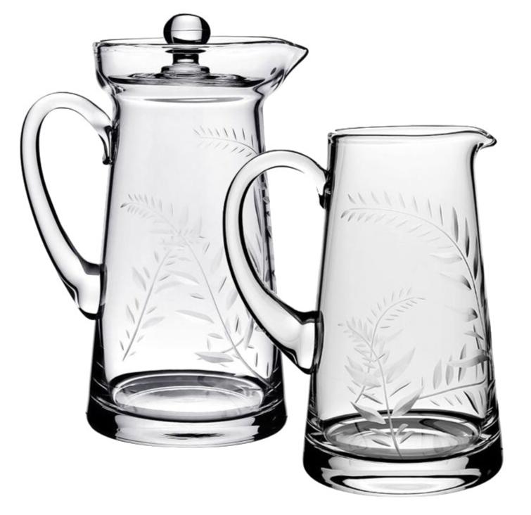 The Jasmine Pitcher Collection by William Yeoward Crystal features two clear glass pitchers with engraved fern leaves, one lidded and one open—an elegant pair displayed side by side, perfect as a treasured wedding gift.