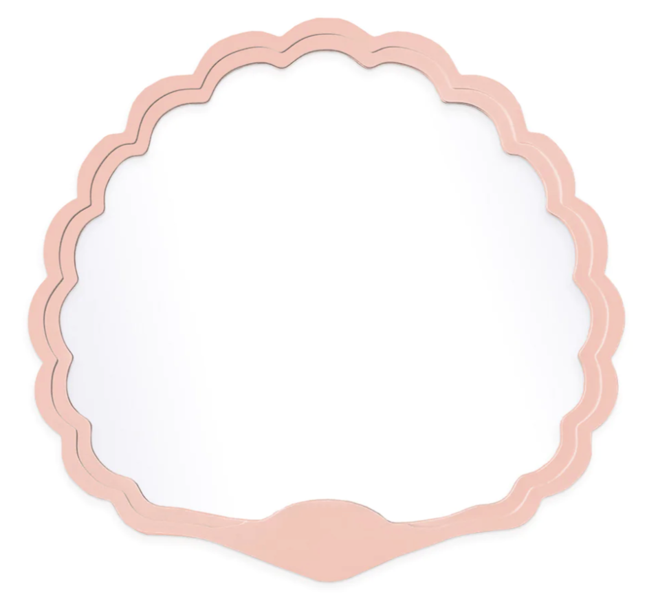 The Carnival Proteus Mirror by Fleur Home features a scallop shell shape, pink frame, and curved edges—perfect for adding Mardi Gras Krewe flair to any New Orleans-inspired space. Photographed against a white background.