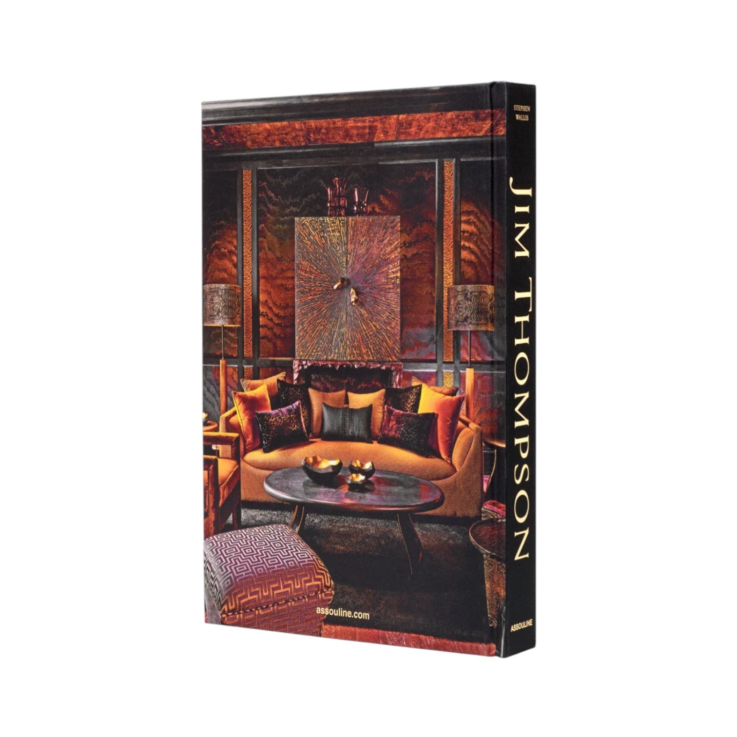 A hardcover book titled "Jim Thompson, Beyond Silk, Beyond Thailand" by Assouline featuring a cover image of a luxurious living room with orange and brown hues, decorative cushions, and elegant Thai silk accents.