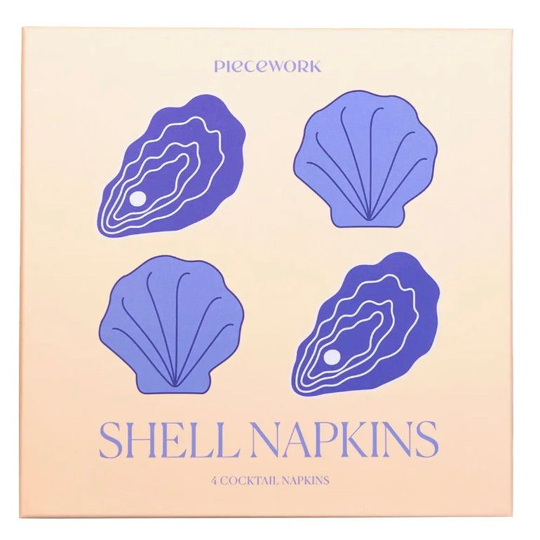 Square box packaging for Piecework Shell Cocktail Napkins featuring four purple shell illustrations and text reading “Shell Napkins 4 Cocktail Napkins.”