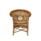 The Julianna Occasional Chair by Varnish Collection features a back view of artisanal rattan with a woven lattice and central circular floral pattern, plus a light seat cushion—crafted from natural materials.