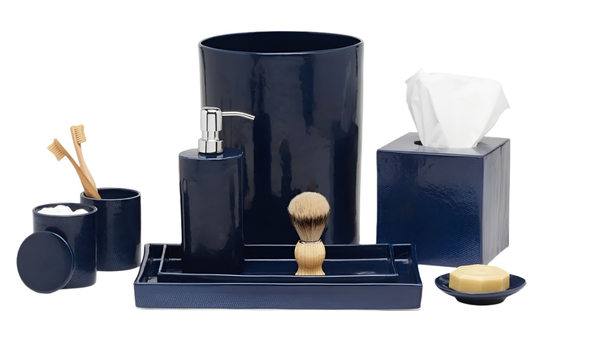 The Cordoba Navy Bath Collection by Pigeon & Poodle features hand-textured ceramic pieces—waste bin, tissue box, soap dispenser, toothbrush holder, lidded cup, shaving brush, tray, and soap dish with soap—displayed on a white background.