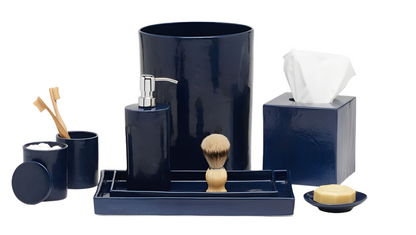 The Cordoba Navy Bath Collection by Pigeon & Poodle features hand-textured ceramic pieces—waste bin, tissue box, soap dispenser, toothbrush holder, lidded cup, shaving brush, tray, and soap dish with soap—displayed on a white background.