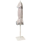 The Montecito Hex Umbrella by Santa Barbara Umbrella is a closed white patio umbrella with blue trim, tied at the middle and standing upright on a square base—perfect for adding elegance to any stylish outdoor space.