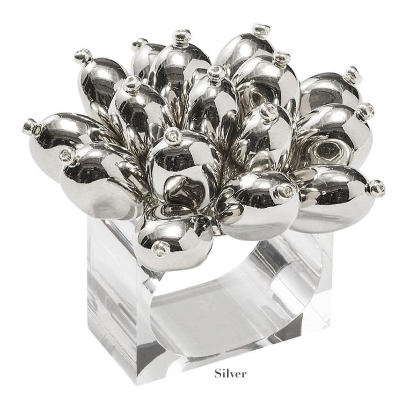 The Jubilee Napkin Ring by Kim Seybert features a cluster of shiny, silver bulb-shaped ornaments on a clear square band—ideal for festive occasions or elevating your table setting. Labeled "Silver" below.