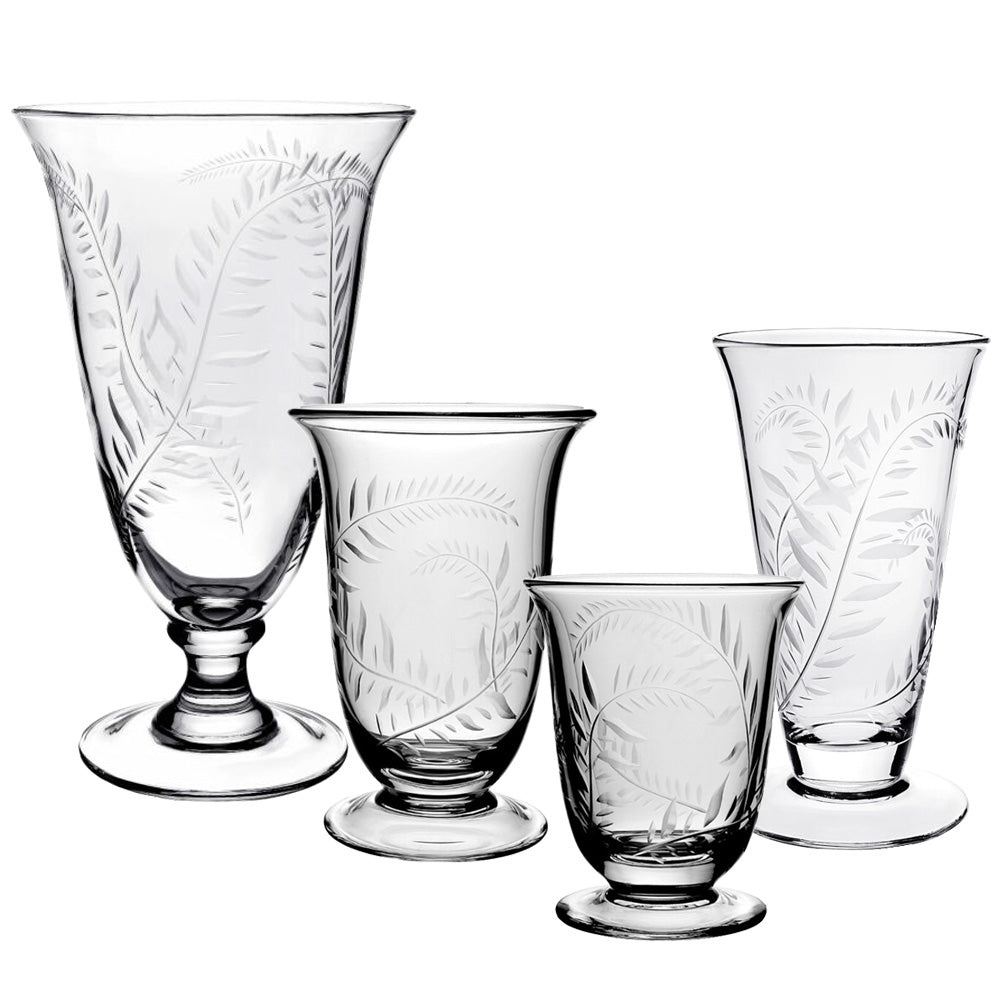 Four vases from the Jasmine Flower Vase Collection by William Yeoward Crystal, featuring handmade etched leaf designs inspired by a jasmine vine motif, are displayed in a row against a white background.