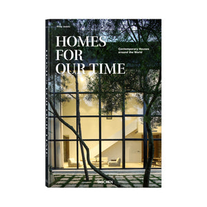 The cover of Taschen’s "Homes For Our Time" displays a modern house with expansive glass windows amid trees, highlighting striking contemporary architecture and inspiring home designs.