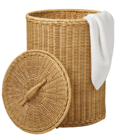 The Pigeon & Poodle Morris Hamper is a round, hand-woven basket with a matching lid resting nearby and a white towel draped over its rim.