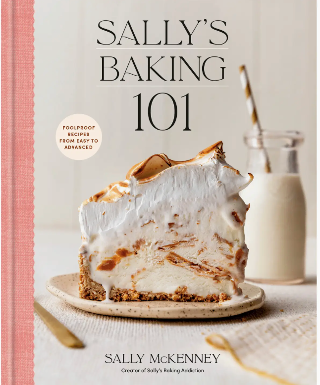 Cover of *Sally’s Baking 101* by Penguin Random House, inspired by Sally’s Baking Addiction, showcasing a generous slice of meringue-topped pie on a plate beside a glass of milk with a striped straw—a mouthwatering introduction to irresistible baking recipes and homemade treats.