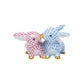 Herend’s Kissing Bunnies are two hand-painted porcelain rabbit figurines, one pink and one blue, with gold-tipped noses touching and a signature scale-pattern design.