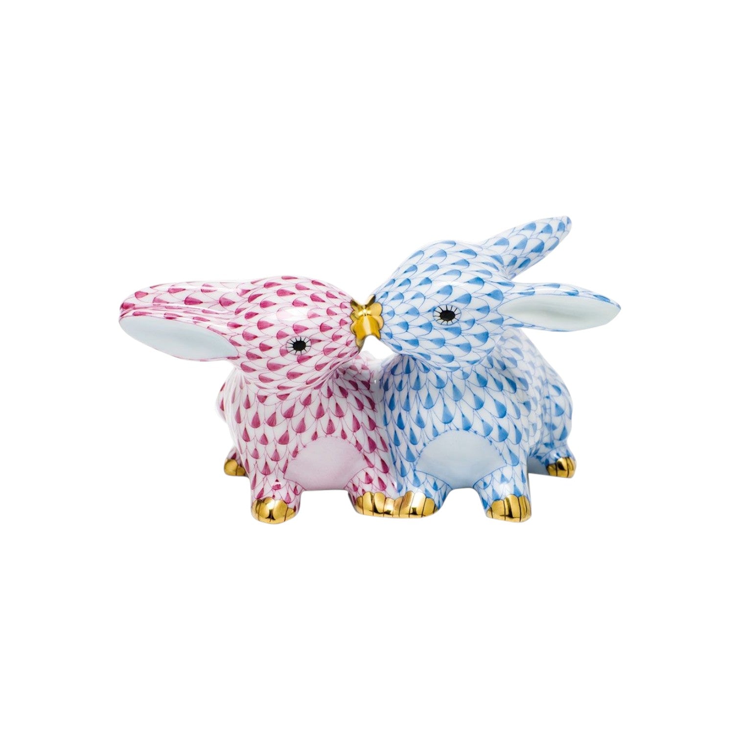 Herend’s Kissing Bunnies are two hand-painted porcelain rabbit figurines, one pink and one blue, with gold-tipped noses touching and a signature scale-pattern design.