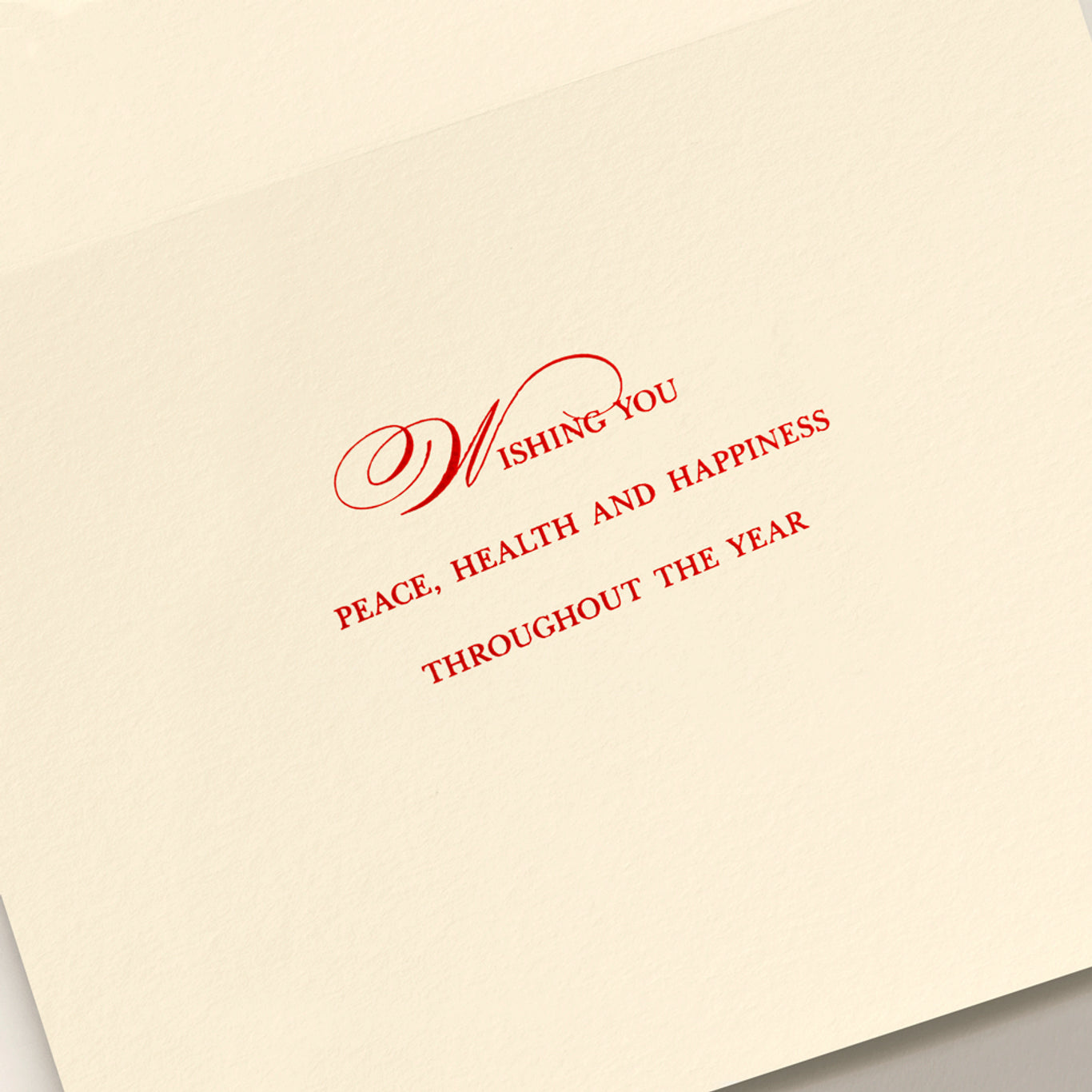 The Ribbon Flourish Merry Christmas Card Set by Crane features cream-colored cards with red engraved text reading, "Wishing you peace, health and happiness throughout the year.
