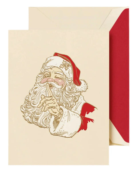 The Crane Santa Claus Wink Card Set features a vintage-style Christmas card with an illustration of Santa Claus holding a finger over his lips, detailed with engraved design, accompanied by a red envelope.