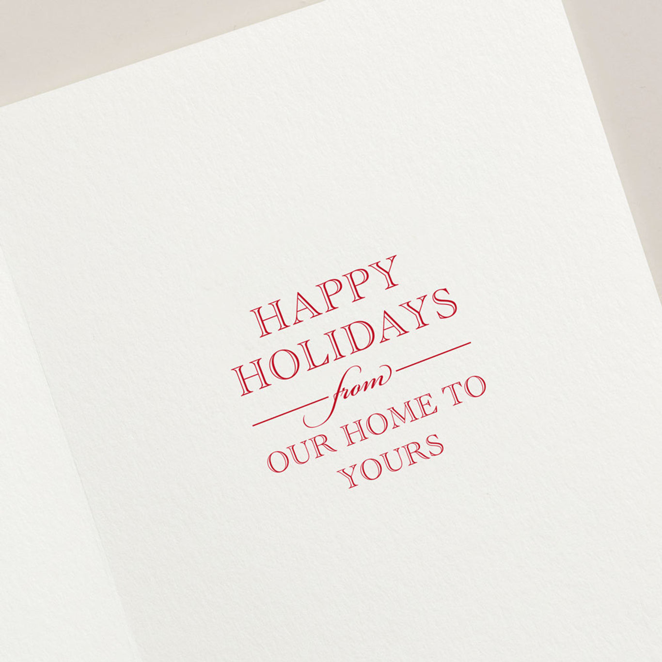 The Crane Red Berry Wreath Card Set by Crane features a holiday card with vibrant red text saying, "Happy Holidays from our home to yours," beautifully set against a crisp white background and complemented by elegantly engraved foliage.