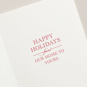 The Crane Red Berry Wreath Card Set by Crane features a holiday card with vibrant red text saying, "Happy Holidays from our home to yours," beautifully set against a crisp white background and complemented by elegantly engraved foliage.