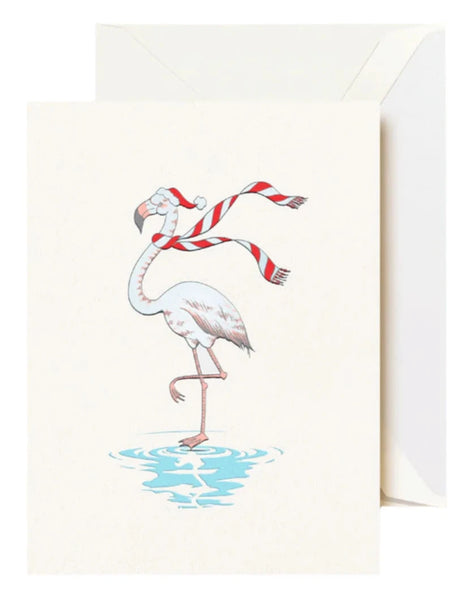 The Crane Festive Flamingo Card Set by Crane showcases a charming illustration of a winter flamingo dressed in a Santa hat and striped scarf, elegantly perched on one leg in the water. Ideal for sending holiday wishes or as a joyful greeting card to spread festive cheer.