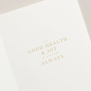 The Crane New Year Wishes Card Set features a card adorned with gold text saying, "May good health & joy be with you always." Ideal for the holiday season, it exudes warmth and conveys heartfelt well-wishes.