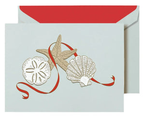 The Crane Elegant Christmas Seashells Card Set features a seaside card with sand dollar, starfish, and scallop shell designs accented by a red ribbon, plus a matching envelope with red lining—ideal for adding coastal charm to your holiday greetings.
