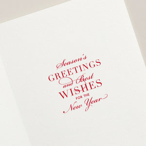The Crane Snowflake Ornament Card Set features white holiday cards with red cursive and serif text, "Season’s greetings and best wishes for the New Year," accented by a delicate silver snowflake ornament for festive charm.