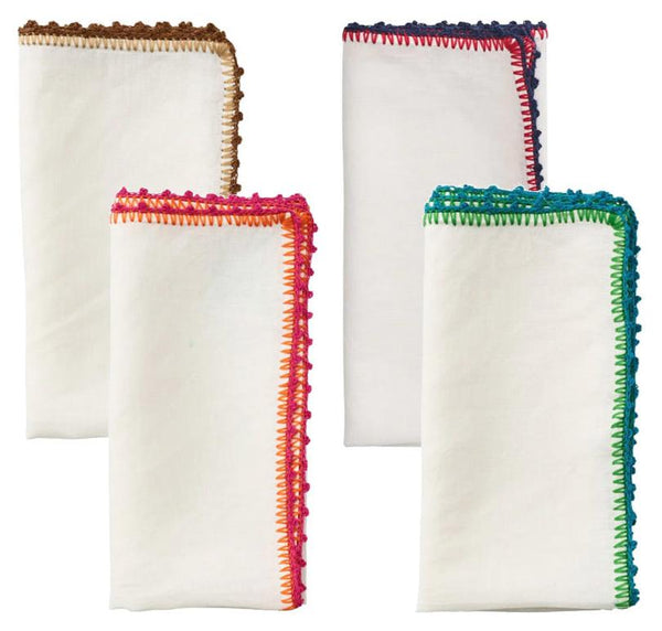 The Kim Seybert Knotted Edge Napkin Set features four white napkins with hand-crocheted edges in vibrant brown, pink, blue, and green hues, all crafted from 100% linen for elegance.