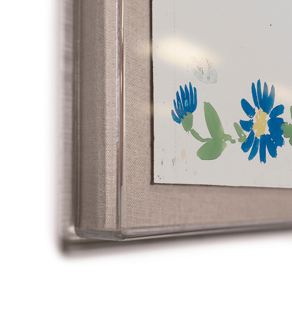 Close-up of the "Habitat Naturelle 1 by Paule Marrot" framed artwork from Soicher Marin, featuring part of a blue flower and green leaf design in the lower right corner against a neutral background, inspired by Paule Marrot prints for an elegant touch.