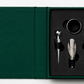 The Essentials Wine Tools by PrintWorks is a boxed set featuring a stopper, pourer, drip ring, and corkscrew in black foam inside a stylish green case—perfect for gifting.