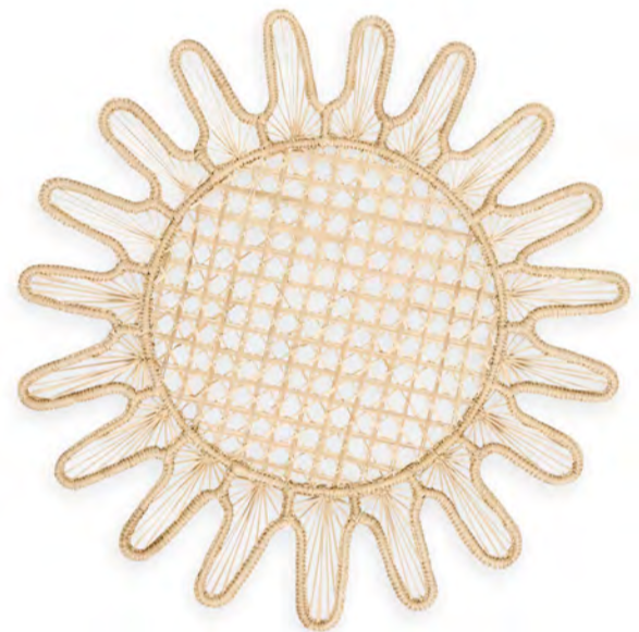 A round woven placemat with a sunburst pattern and open lattice center, handcrafted by Colombian artisans from natural fibers. Part of Themis Z's Kyma Rattan Placemat Collection.