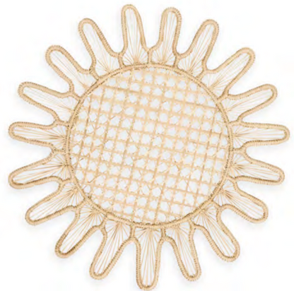 A round woven placemat with a sunburst pattern and open lattice center, handcrafted by Colombian artisans from natural fibers. Part of Themis Z's Kyma Rattan Placemat Collection.