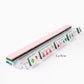 The Oh My Mahjong Tile Collection by Oh My Mahjong offers a transparent rack with pink-tiled, hand-painted Mahjong tiles featuring colorful symbols to enhance your gaming experience.