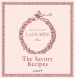 A pale pink book cover adorned with a floral wreath, featuring the text “Ladurée” and the title “The Savory Recipes” in bold lettering beneath—evoking the charm of the renowned Parisian tea salon where the macaron originated—published by Simon & Schuster.