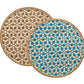 The Lanai Placemat Collection by Kim Seybert features two round rattan placemats with a star pattern—one in brown, one in blue and beige—both finished with natural fiber borders for added style.