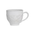 The Juliska Le Panier Mystic Knot Collection white ceramic mug showcases signature hand-knotted braid details and a textured pattern around the body and handle, set against a sleek white background.