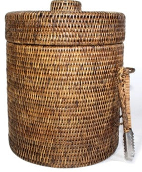 A cylindrical round Matahari Rattan Ice Bucket with Liner in Antique Brown Collection features a matching lid and a pair of metal tongs attached on the side, making it both stylish and practical.