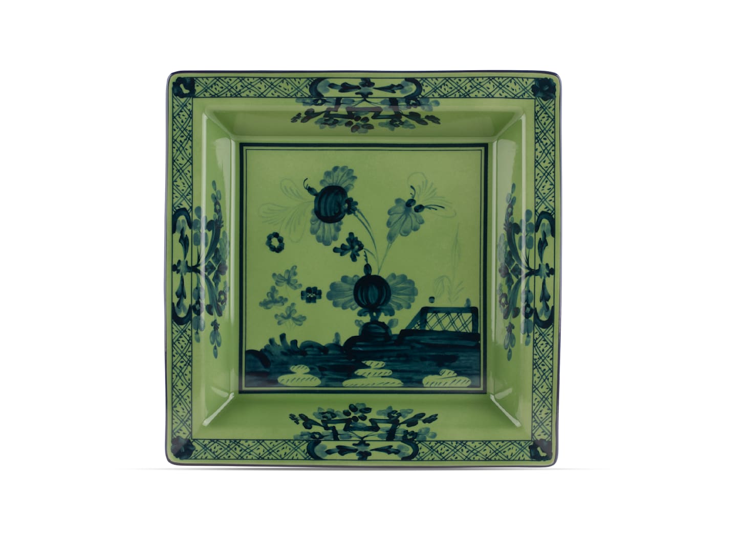 The Oriente Italiano Malachite Dinnerware & Decor Collection by Ginori 1735 features a rectangular green ceramic plate adorned with blue floral motifs and geometric borders, blending exotic charm and the elegance of Italian porcelain.